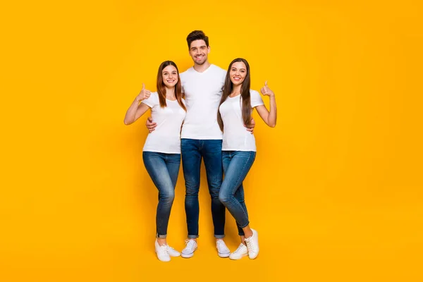 Foto em tamanho real de meninas alegres cara mostrando polegar para cima sorrindo vestindo branco t-shirt jeans jeans jeans isolado sobre fundo amarelo — Fotografia de Stock