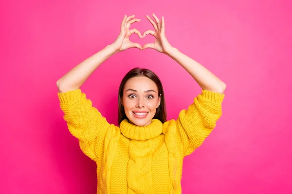 Retrato de senhora alegre fazendo coração de seus dedos sorrindo usando suéter amarelo isolado sobre fundo fúcsia — Fotografia de Stock