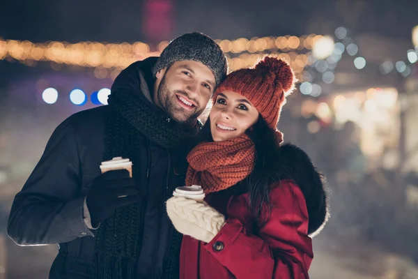 Foto de duas pessoas bonitas emparelhar com bebida quente nas mãos passar a noite de x-mas no concerto do ano novo ouvir canções tradicionais vestindo casacos quentes — Fotografia de Stock