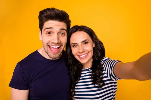 Selbstporträt von charmant schönen netten Ehepaar lächelt in die Kamera zeigt ihre Zähne, während isoliert mit gelbem Hintergrund — Stockfoto