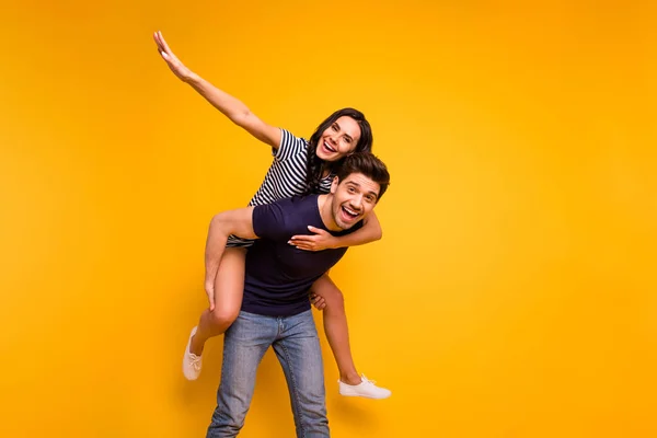 Foto de casal legal agradável alegre louco vestindo jeans denim sorrindo toothily rindo enquanto isolado com fundo amarelo — Fotografia de Stock