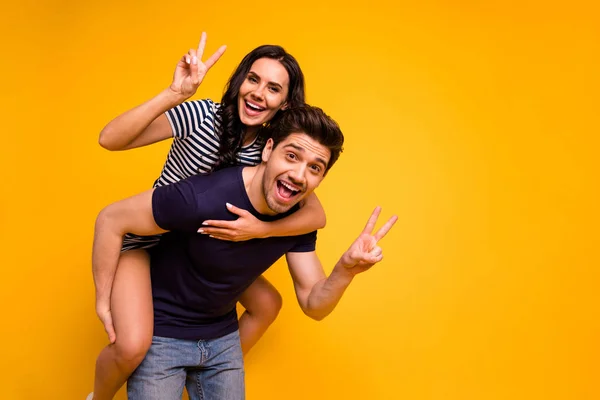 Foto de la loca pareja alegre agradable de dos personas que le muestra v-signo mientras está aislado con fondo amarillo —  Fotos de Stock