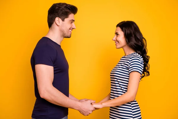 Profile side view portrait of his he her she nice attractive lovely tender affectionate cheerful cheery married spouses holding hands isolated on bright vivid shine yellow background — Stockfoto