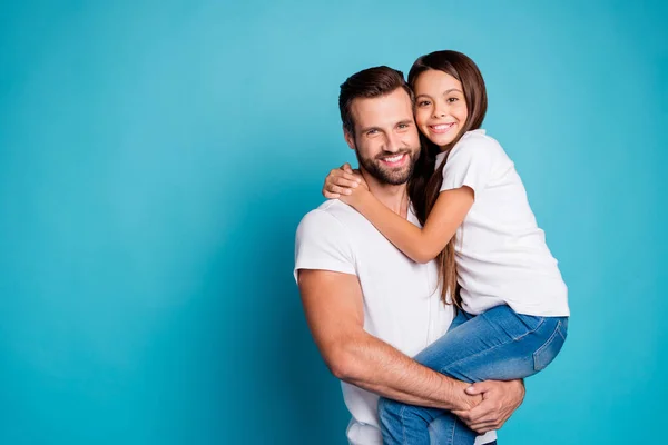 Portret van mooie man met Brunet haar knippen houden van zijn dochter hebben lang haar dragen witte casual t-shirt denim jeans geïsoleerd over blauwe achtergrond — Stockfoto