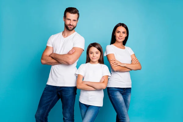 Retrato de familia enfocada con cabello moreno cruzando sus manos mirando con camiseta blanca vaqueros aislados sobre fondo azul — Foto de Stock