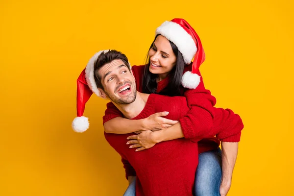 Portrait of cheerful man hug his wife piggyback wear red pullover isolated over yellow background — ストック写真