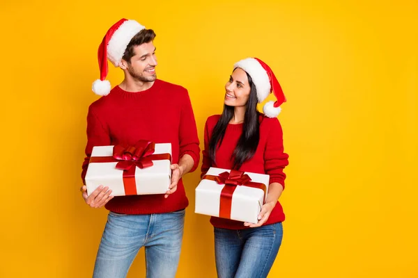 Portrait of positive married people with brown hair get packages wear red pullover denim jeans isolated over yellow background — Stock fotografie