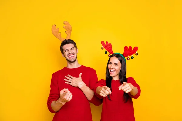 Portrait of cheerful man and woman laugh tease direct with index finger wear red sweater isolated over yellow background — Stock Photo, Image