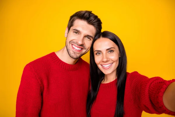 Крупним планом фото чарівних мрійливих подружжя беруть автопортрет в червоному пуловері ізольовані на жовтому тлі — стокове фото
