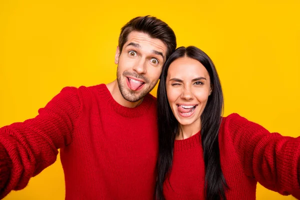 Close up foto van vrolijke echtgenoten grimas nemen zelfportret dragen rode trui geïsoleerd over gele achtergrond — Stockfoto