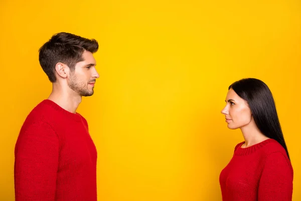 Profilseite Foto von konzentrierten Mann und Frau starren von Angesicht zu Angesicht tragen roten Pullover isoliert über gelbem Hintergrund — Stockfoto