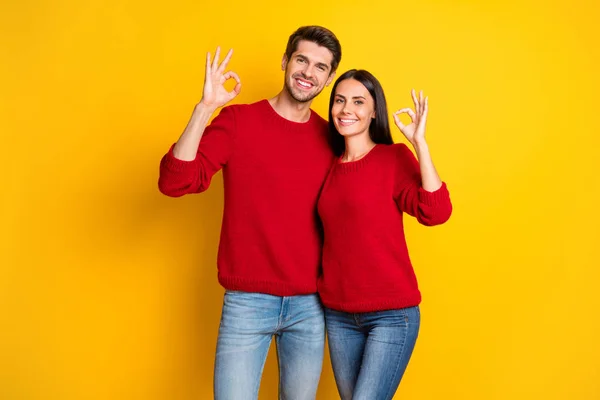 Retrato de charmoso casal mostrar ok sinal recomendo anúncios usar pulôver vermelho jeans jeans jeans isolado sobre fundo amarelo — Fotografia de Stock