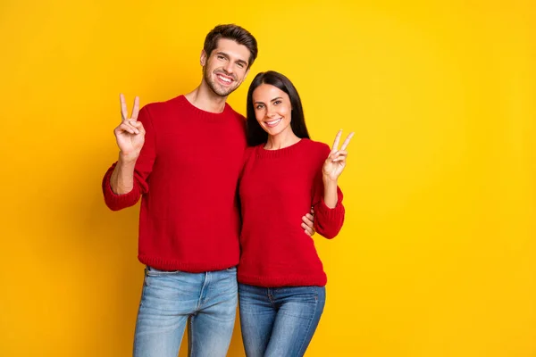 Retrato de casal alegre fazer v-sinais desgaste pulôver vermelho isolado sobre fundo amarelo — Fotografia de Stock