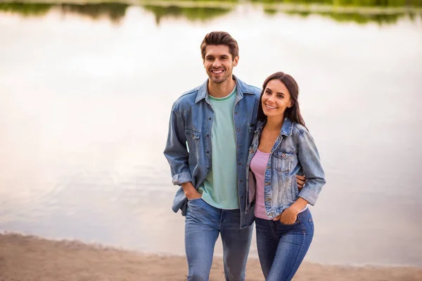 Portrait of charming married couple hug moving wearing denim jeans jackets blazers outdoors in park — Stock Photo, Image