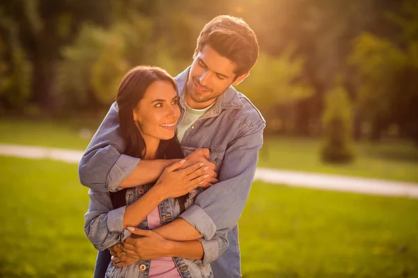 Portrait of charming married millennial cuddling piggyback wearing denim jeans jackets blazers outdoors — 图库照片