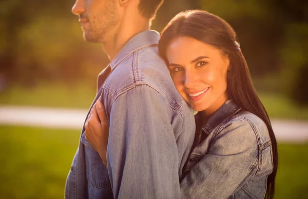 Profile side cropped photo of charming woman with brunette hair cuddling her husband smiling wearing denim jeans jackets blazers outdoors — Stock Photo, Image