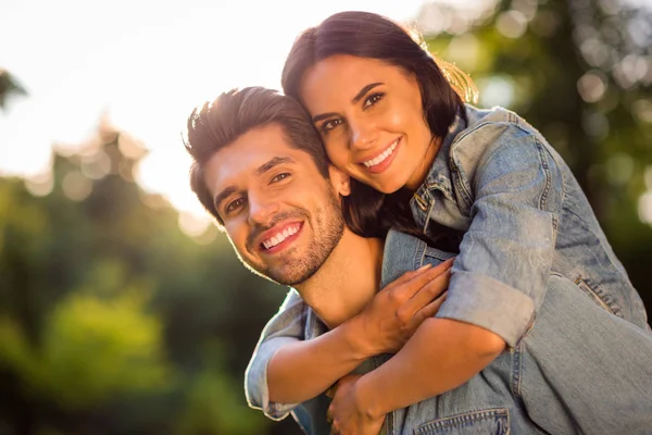 Nahaufnahme von charmanten Ehepartnern mit brünetten Haaren, die huckepack draußen im Wald kuscheln — Stockfoto