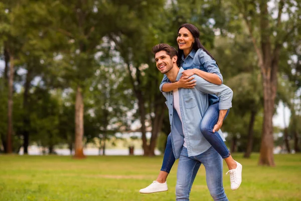 Foto de lindo par finalmente divertirse vacaciones juntos caminando calle verde fuera desgaste traje de mezclilla — Foto de Stock