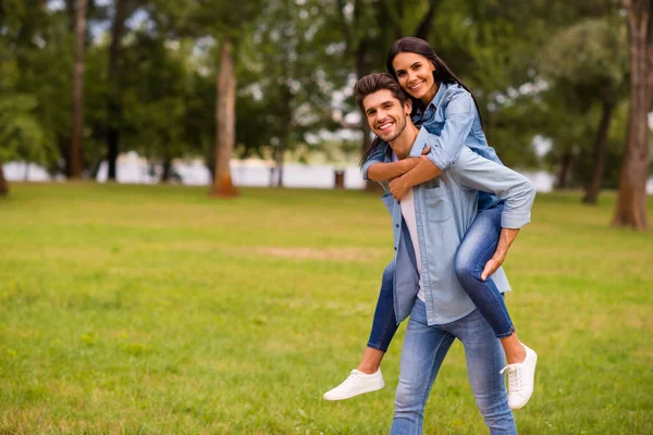 Pretty par äntligen ha kul semester tillsammans Walking Green Street utanför slitage denim outfit — Stockfoto