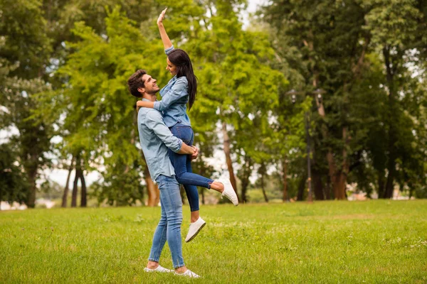 Foto de perfil de cuerpo completo de la pareja llena de alegría en el parque verde celebrando aniversario de desgaste traje de mezclilla casual —  Fotos de Stock