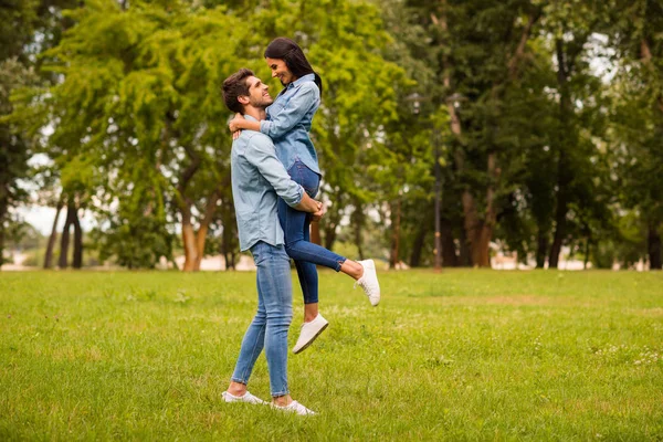 Foto de perfil de longitud completa de la pareja llena de alegría en el parque verde celebrando aniversario de desgaste traje de mezclilla casual —  Fotos de Stock