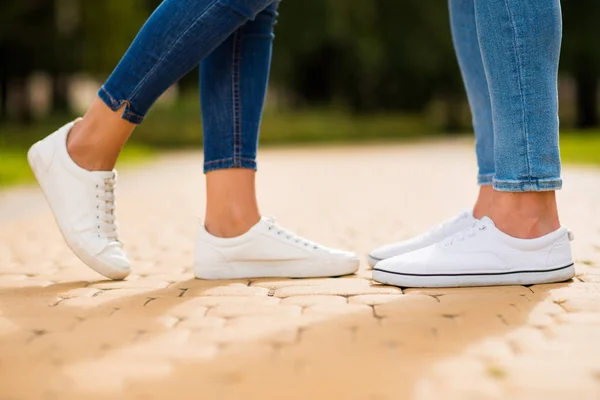 Kroppsfoto av sjarmerende parbein som går grønn solskinnsdag nedover parken, bruk denim-antrekk – stockfoto