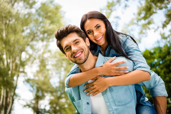 Baixo ângulo vista foto de bonito par regozijando-se juntos caminhando verão verde parque ao ar livre usar roupa jeans — Fotografia de Stock