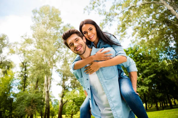 Baixo ângulo vista foto de bonito par regozijando-se juntos caminhando verão verde parque ao ar livre usar roupa jeans — Fotografia de Stock