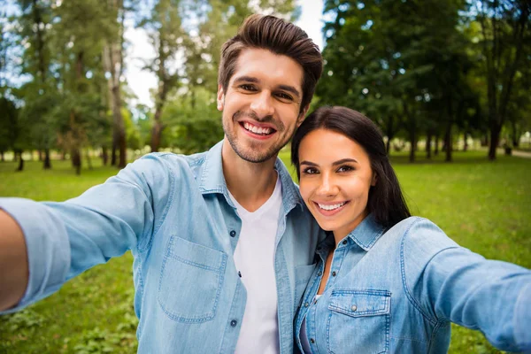 Zbliżenie zdjęcie uroczych małżonków podejmowania zdjęcie przytulanie obejmując noszenie denim Jeans koszula na zewnątrz w lesie — Zdjęcie stockowe