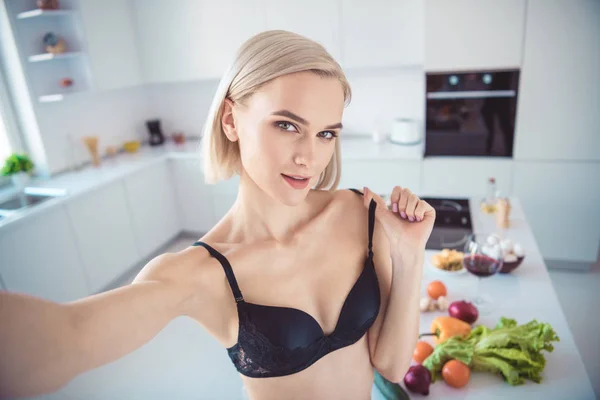 Autorretrato de ella, ella, atractiva, encantadora, dulce, guapa, encantadora, adorable, chica de ensueño, desnudando el sujetador en la moderna cocina interior de color blanco claro en el interior — Foto de Stock