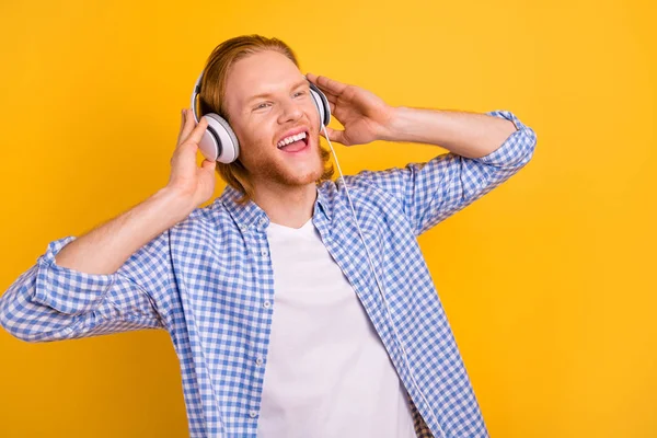 Foto de alegre lindo chico guapo gritando con auriculares gritando palabras y líneas de su canción favorita soñando aislado sobre un fondo de color vibrante —  Fotos de Stock