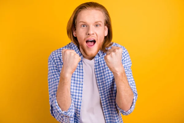 Photo of cheerful crazy overjoyed ecstatic man rejoicing with his favorite sport team victorious grimacing isolated over yellow vivid color background — Stockfoto