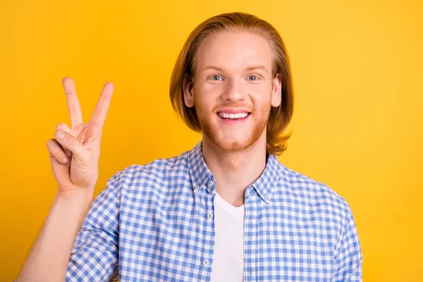 Close-up foto van vrolijke gekke knappe man glimlachend tonen u v-teken dragen geruite kleren geïsoleerd over levendige kleur achtergrond — Stockfoto