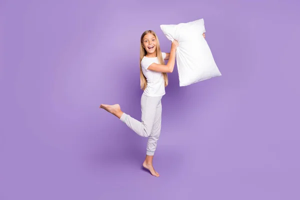 全身照片的搞笑时髦疯狂情绪金发女孩赤脚抱着枕头想玩游戏睡过党与最好的朋友姐妹穿白色T恤裤子孤立的紫色背景 — 图库照片