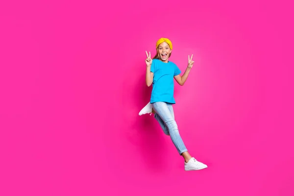 재미 펑키 금발 머리 아이의 전신 사진은 할인 후 재미 점프 실행이 v-징후는 핑크 색상 배경을 통해 고립 데님 청바지 블루 노란색 의상 운동화를 착용 — 스톡 사진