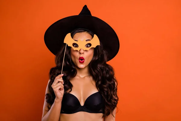 Trick or Treat Halloween koncept foto av vackra naken brunett charmig Lady innehar bat formad trä pinne se stilig Wizard Guy på Party Wear svart häxa mössa isolerad orange bakgrund — Stockfoto