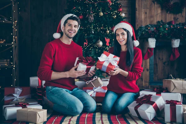 Foto de corpo inteiro de dois cônjuges românticos, as pessoas sentam-se em pacotes de manta xadrez para a celebração de Natal x-mas em casa com decoração de noel dentro de casa — Fotografia de Stock