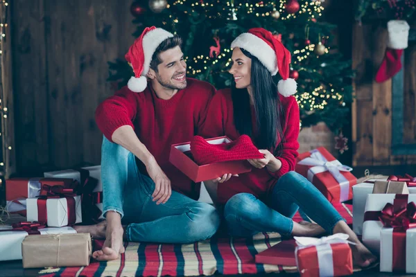 Foto em tamanho completo de dois cônjuges românticos segurar pacote siga a tradição noel comemorar Natal tempo x-mas férias sentar-se em manta xadrez em casa com caixas de presente iluminação decoração dentro de casa — Fotografia de Stock