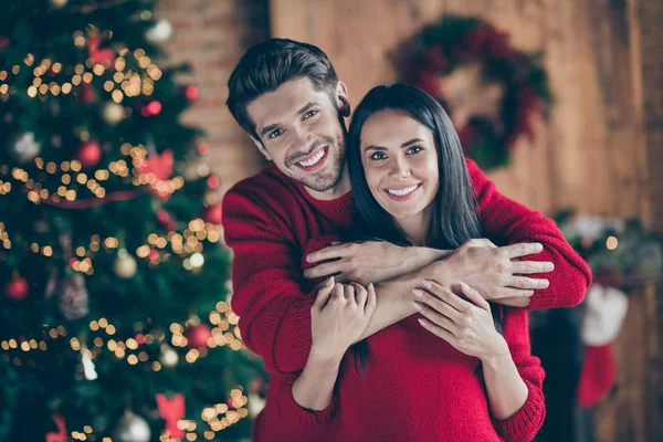 Retrato de dos personas encantadoras románticas abrazo cerca del árbol de Navidad por la mañana disfrutando de vacaciones de Navidad en casa con decoración de año nuevo x-mas luces iluminación interior —  Fotos de Stock