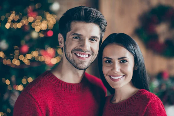 Close up foto de casal romântico encantador com cabelo morena apreciando Natal noite x-mas feriados vestindo pulôver vermelho no quarto com iluminação luzes do ano novo dentro de casa — Fotografia de Stock