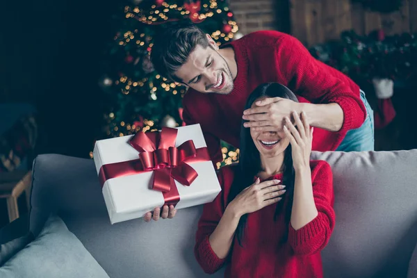 Retrato de duas pessoas românticas cara de perto para sua mulher animada dar sua caixa de presente no ano novo férias de Natal feriados sentar-se no divã em casa decorativa com iluminação x-mas dentro de casa — Fotografia de Stock