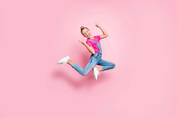 Körpergröße in voller Länge Foto stilvoll trendy niedlich fröhlich jubelnde Mädchen trägt Jeans Jeans Gesamt T-Shirt fuchsia Springen zeigt Rock-Zeichen isoliert über rosa Pastellfarbe Hintergrund — Stockfoto