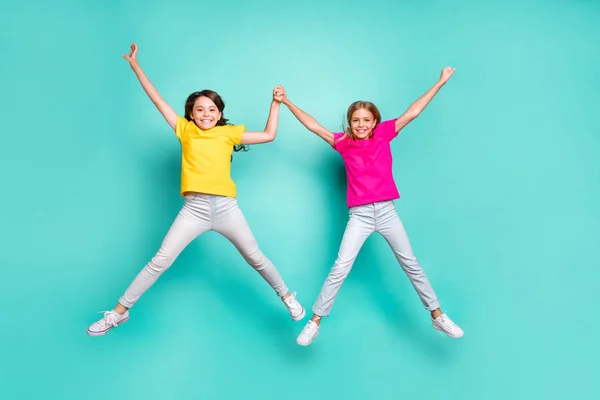 Comprimento total do corpo tamanho foto de duas pessoas bonitas bonito agradável meninas pulando como estrelas, enquanto isolado com fundo teal — Fotografia de Stock