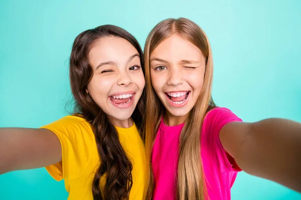 Foto de dos chicas divertidas excitadas lindas agradables casuales que aman tomar fotos fotografiándose mientras están aisladas con fondo verde azulado —  Fotos de Stock