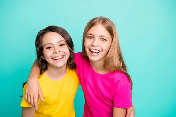 Foto de dos amables chicas hermosas increíbles que se alegran de ser fotografiadas mientras están aisladas con fondo verde azulado — Foto de Stock