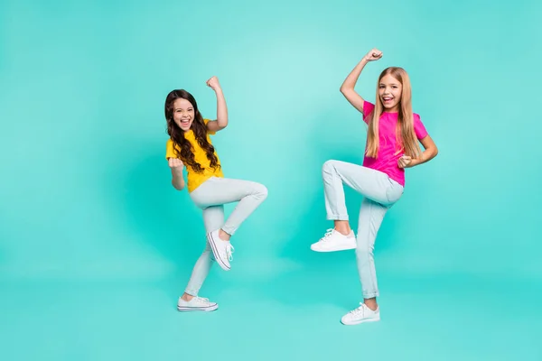 Pleine longueur corps taille photo de deux casual amical mignon agréable copines ayant gagné quelque chose à l'école tandis que isolé avec fond turquoise — Photo