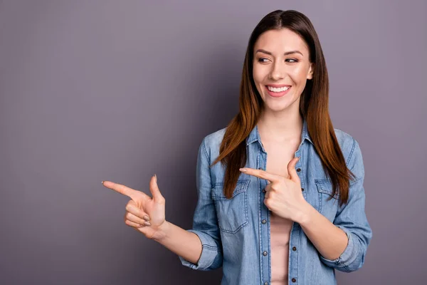 Portrait of positive cheerful promoter point index finger at copyspace recommend ads show sales discounts wear denim jeans clothes isolated over grey color background — Stock Photo, Image