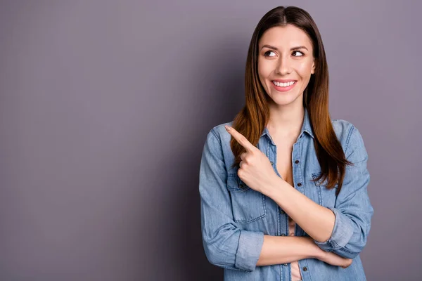 Retrato de positivo alegre promotor freelancer dedo índice en copyspace seguir anuncios buscar descuentos usar jeans ropa aislada sobre fondo de color gris —  Fotos de Stock