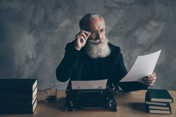 Retrato de su atractivo barbudo centrado concentrado de pelo gris profesional experto editor creativo leyendo noticias historia artículo ensayo sobre fondo de pared de hormigón —  Fotos de Stock