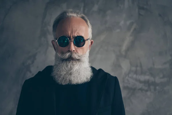 Photo rapprochée de l'homme masculin dur rêveur regardant avec des lunettes de vue portant une veste noire isolée sur fond gris — Photo